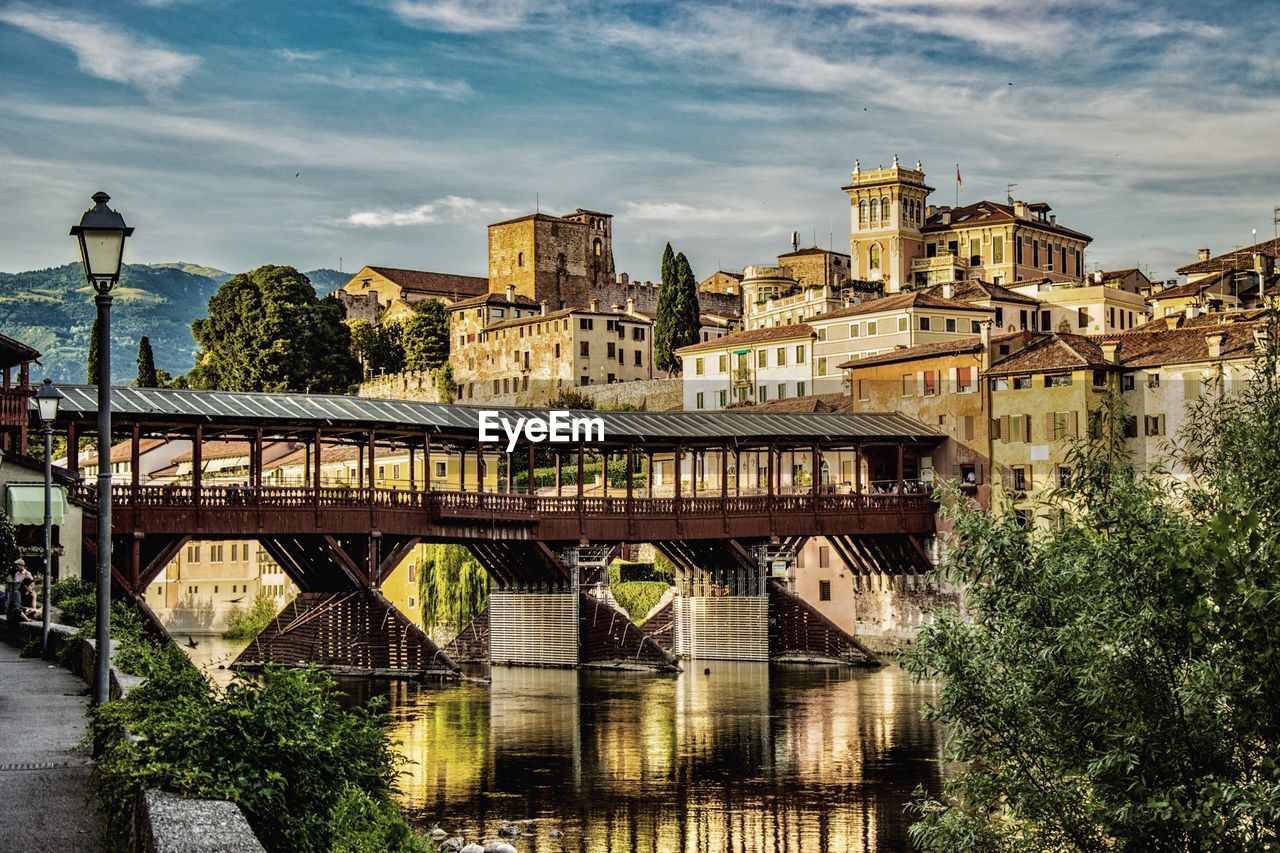 ARCH BRIDGE BY BUILDINGS AGAINST SKY