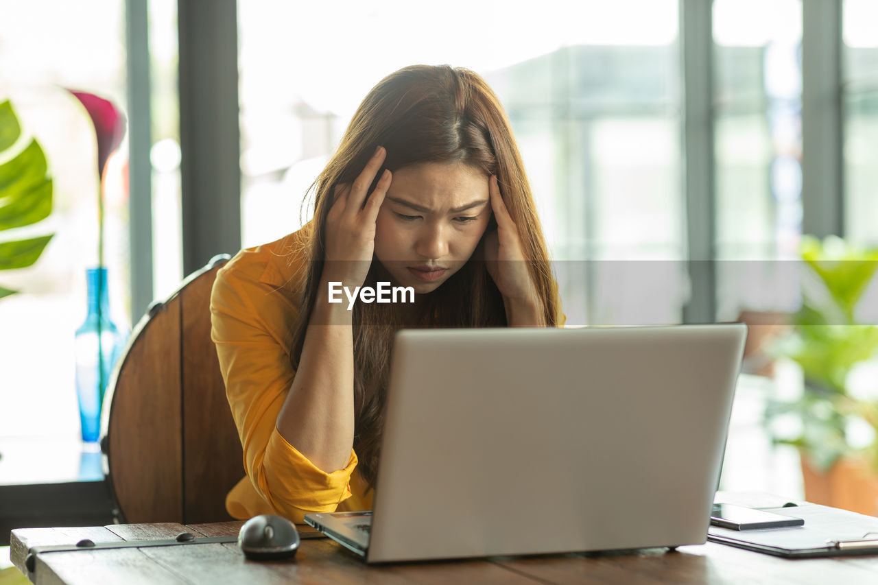 Tired businesswoman working on table at office