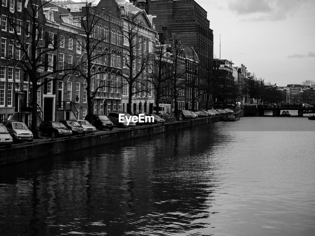 River by buildings against sky at dusk