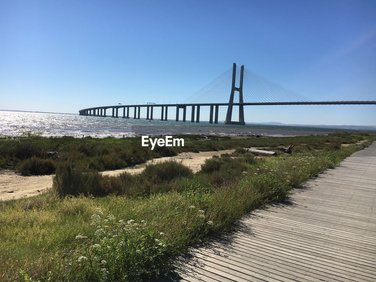 Bridge over river against clear blue sky