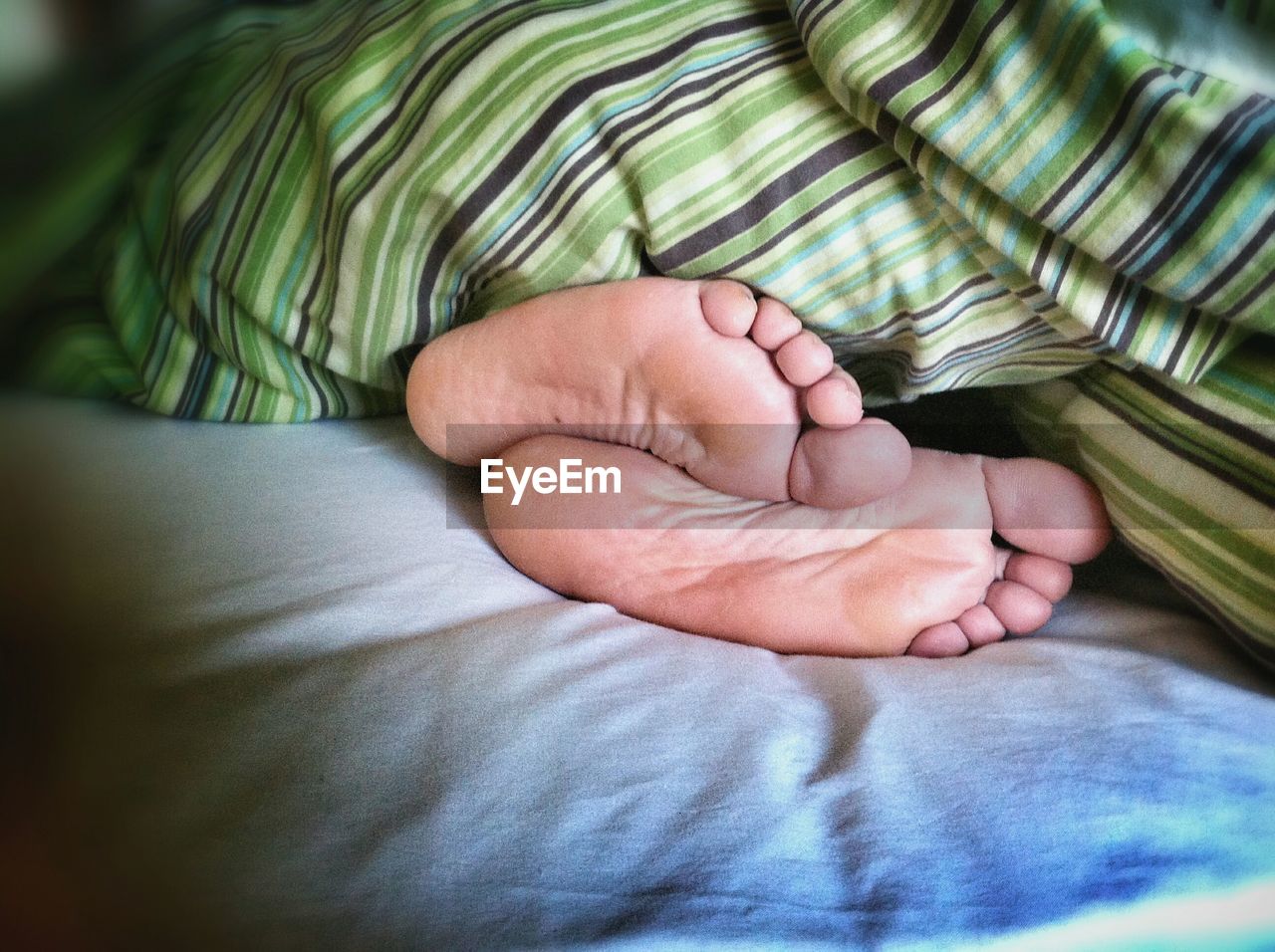 Close-up of woman feet on bed