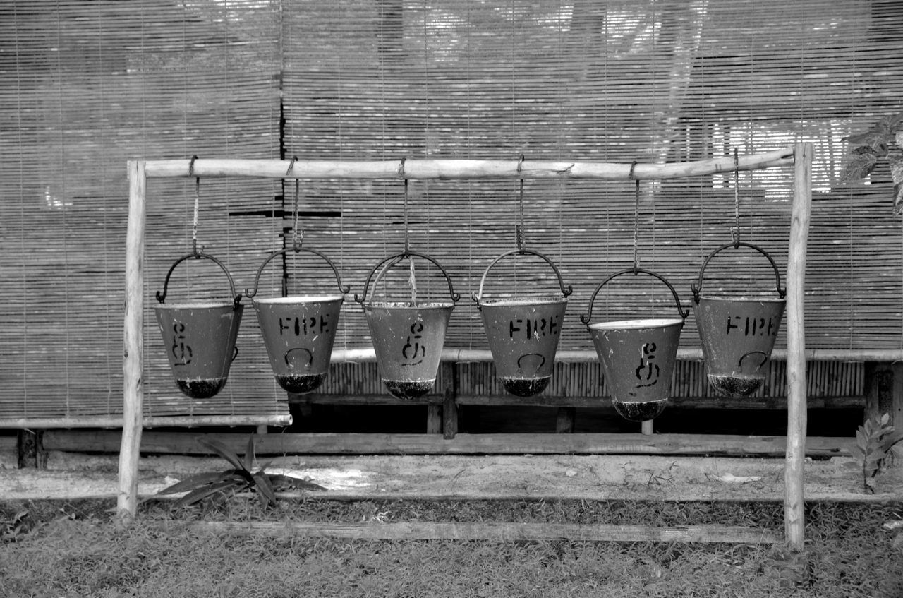 Row of fire buckets hanging on bamboo at yard