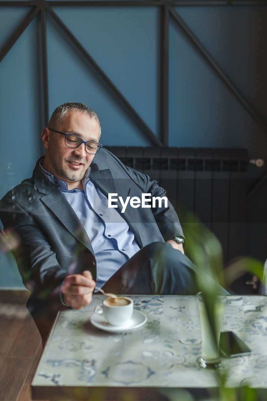 Thoughtful businessman with coffee on table sitting at restaurant