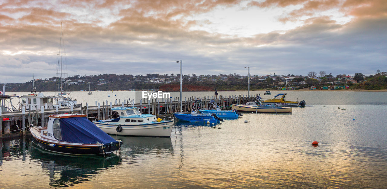 SAILBOATS MOORED IN HARBOR