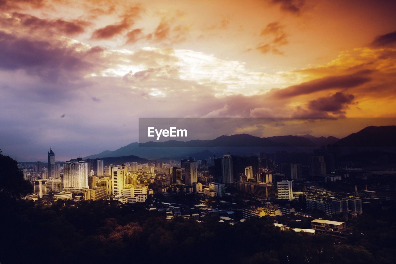 View of cityscape against cloudy sky during sunset