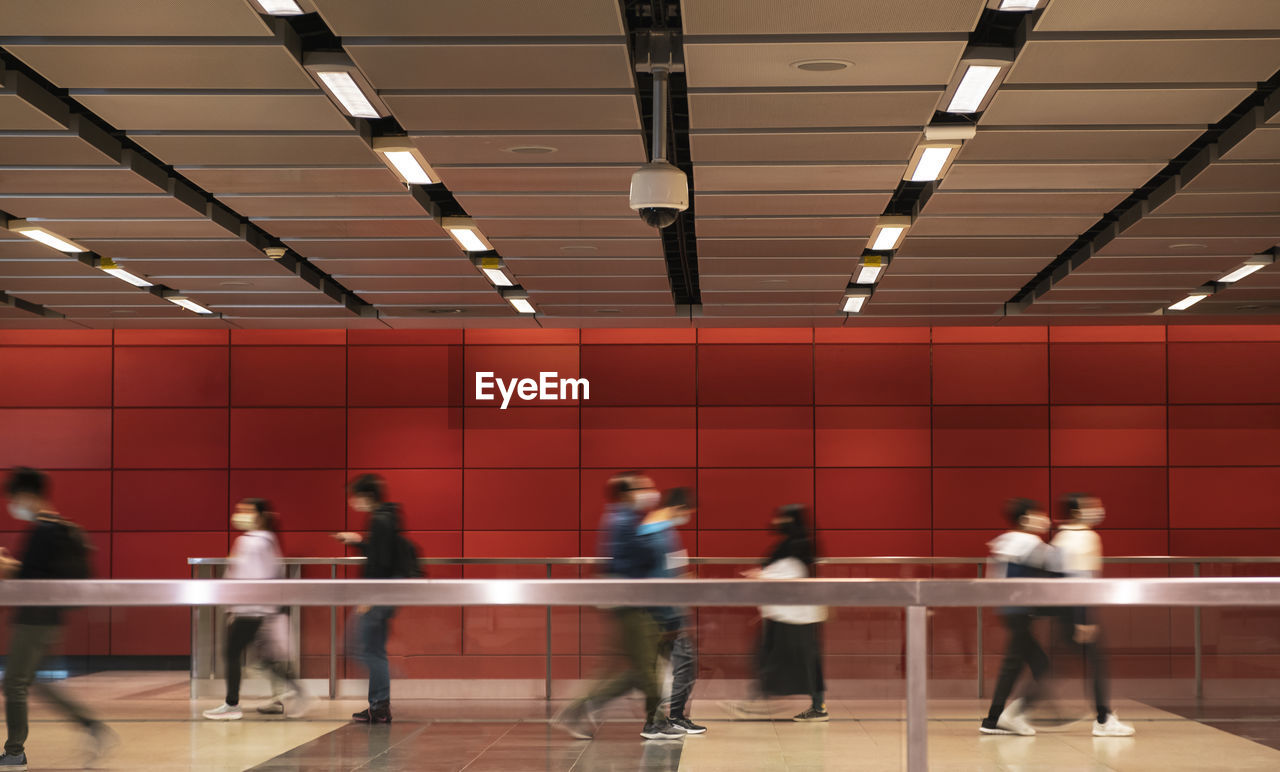 Unidentified people walking at subway station.