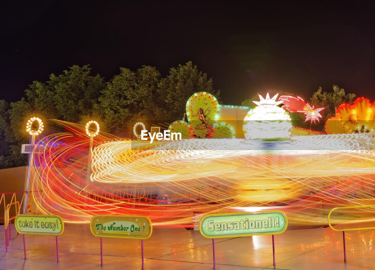 CLOSE-UP OF ILLUMINATED CAROUSEL IN AMUSEMENT PARK