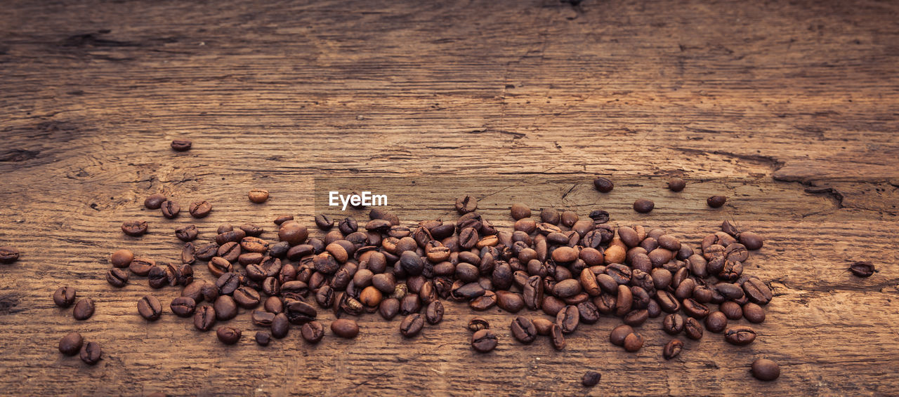 Panoramic shot of roasted coffee beans on wood