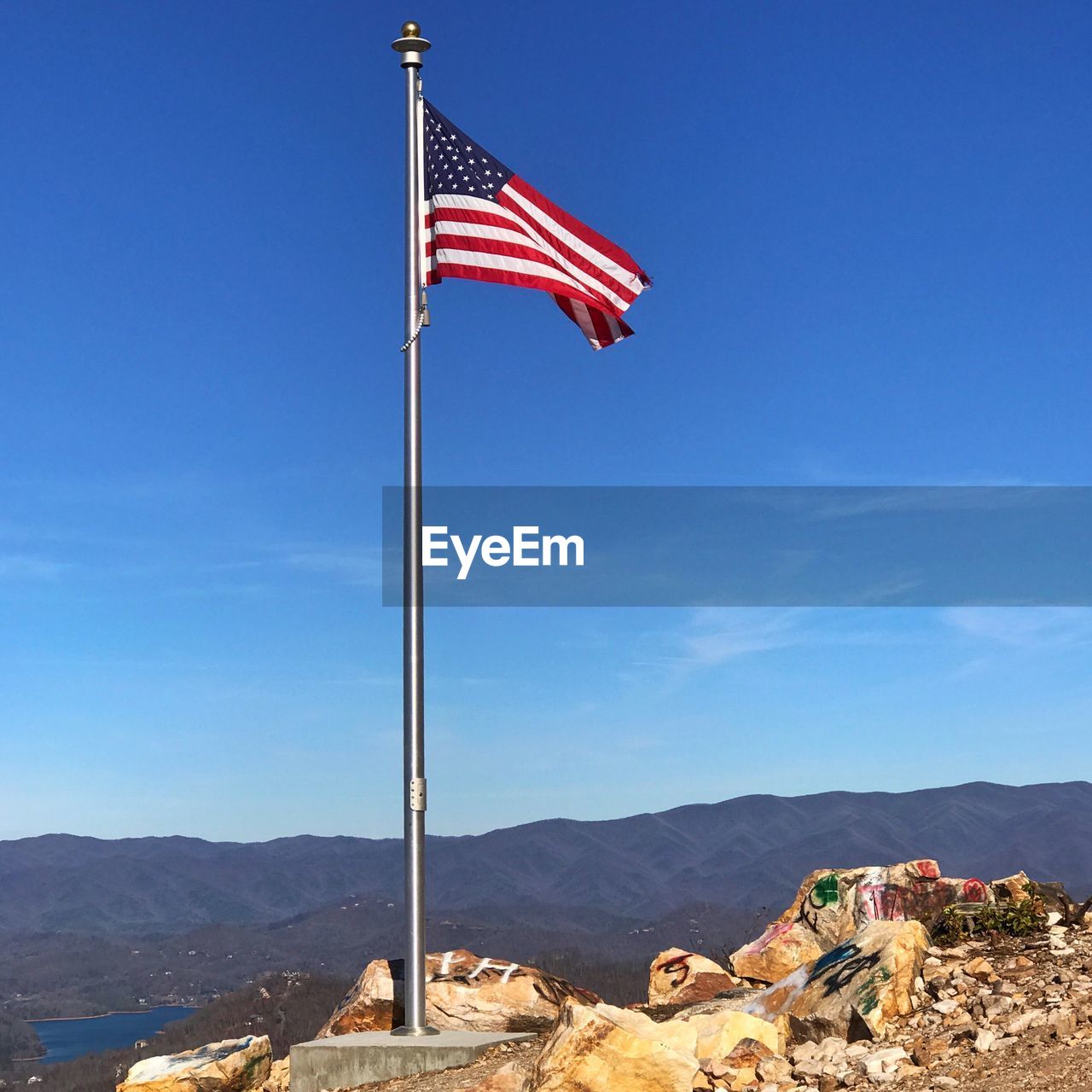 American flag on mountain against blue sky