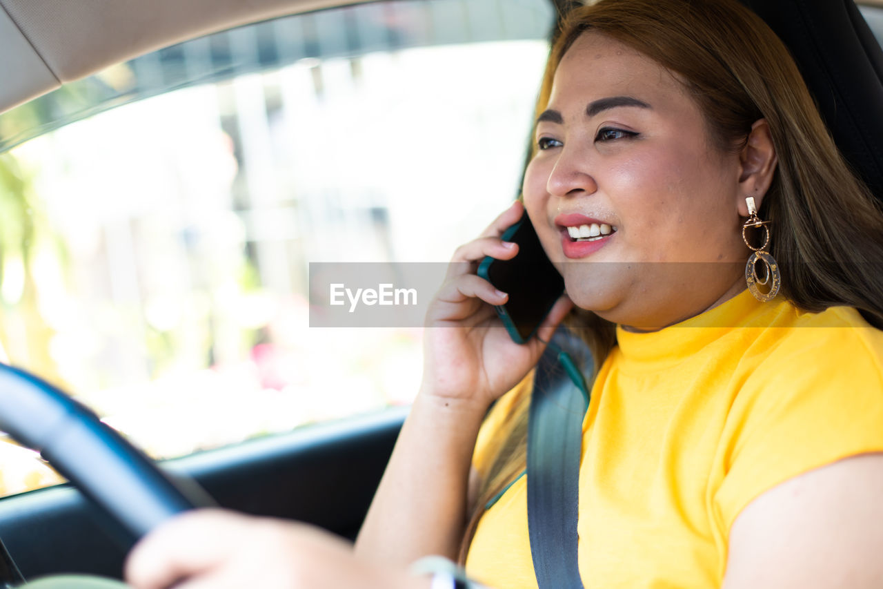 PORTRAIT OF YOUNG WOMAN USING MOBILE PHONE