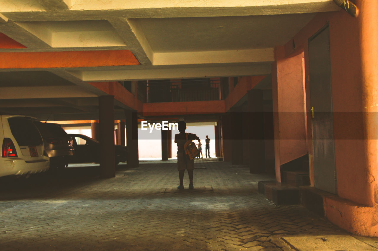 Rear view of boy standing in underground parking lot