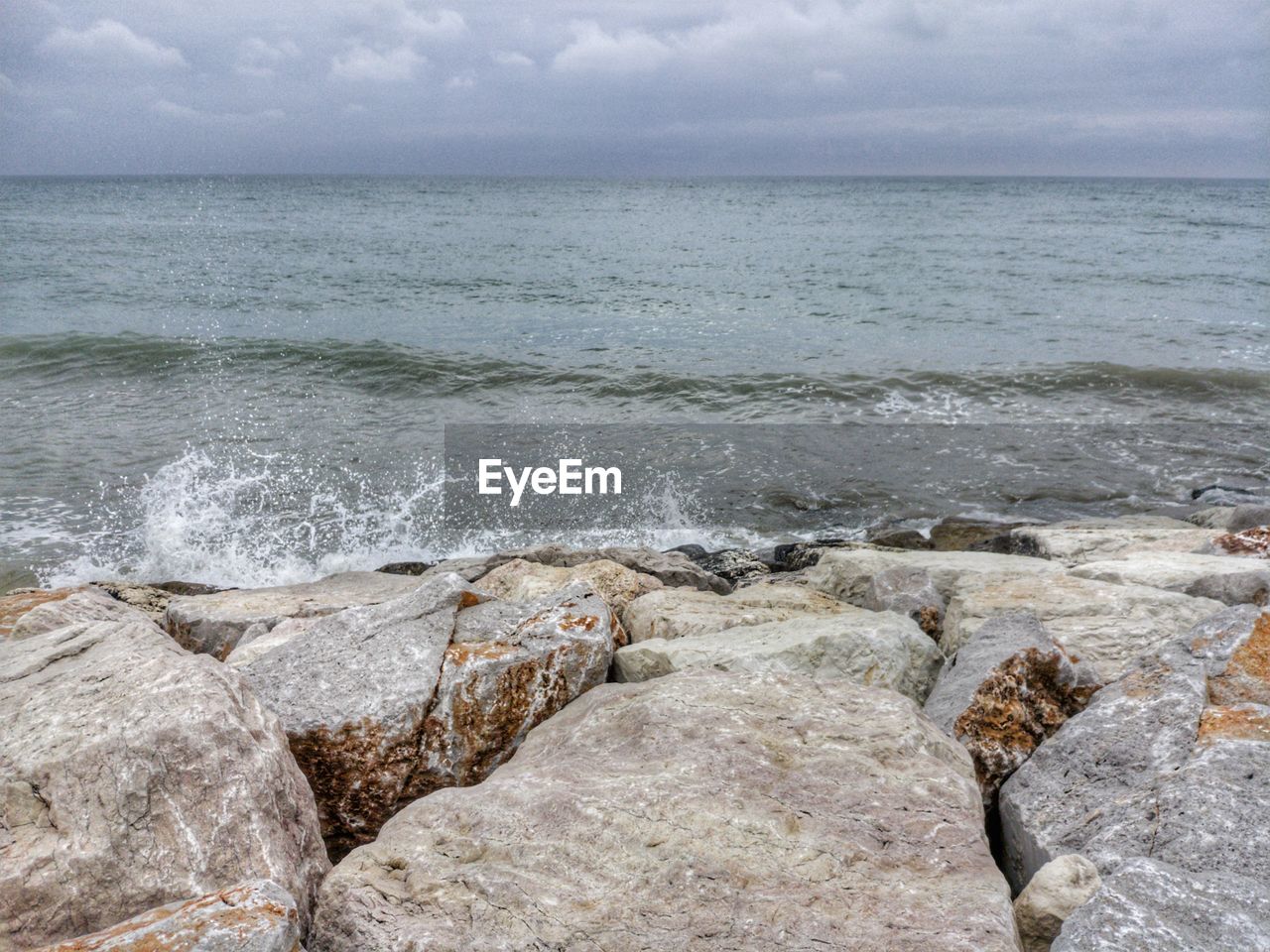 SCENIC VIEW OF ROCKS ON SHORE AGAINST SKY