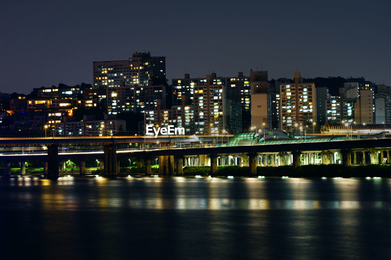 illuminated bridge over river at night