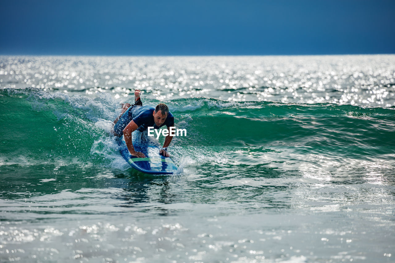 rear view of man surfing in sea