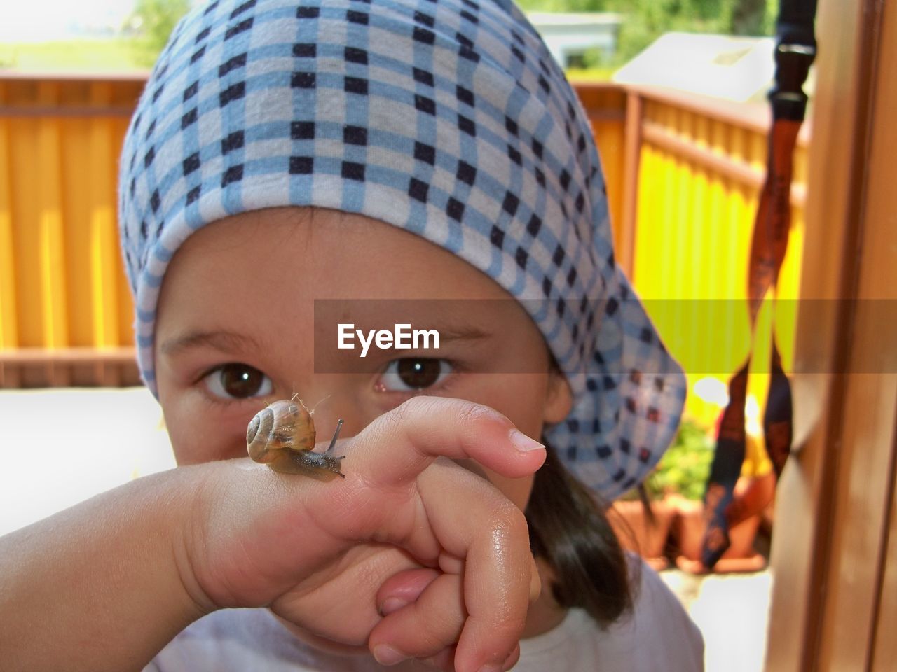 Close-up portrait of girl with snail