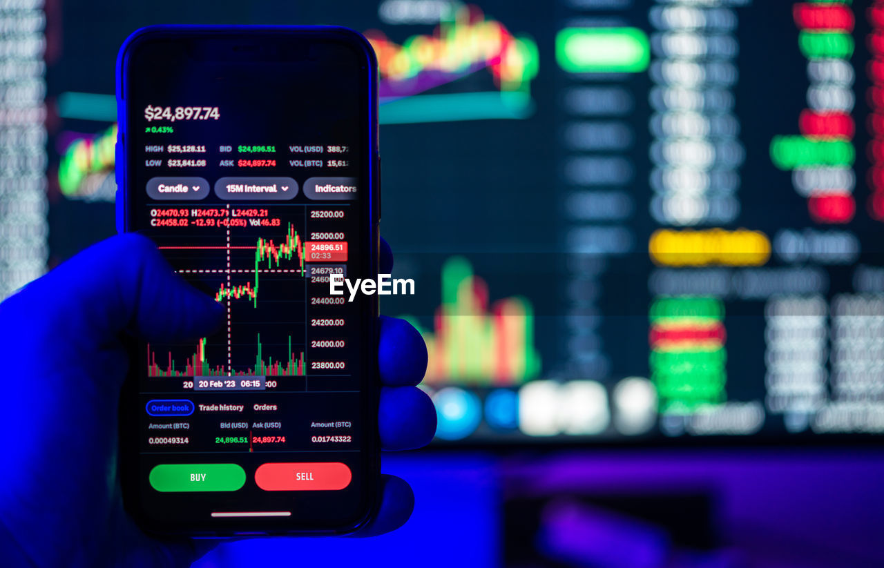 Stock and crypto trading online platforms displayed on a smartphone and desktop screens.