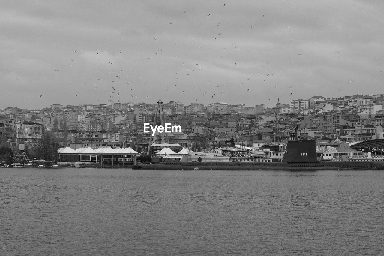 architecture, water, building exterior, built structure, city, sky, building, black and white, cityscape, nature, vehicle, monochrome photography, skyline, no people, monochrome, sea, travel destinations, residential district, horizon, cloud, waterfront, outdoors, transportation, harbor, day, coast, landscape, ship, bird, travel, nautical vessel