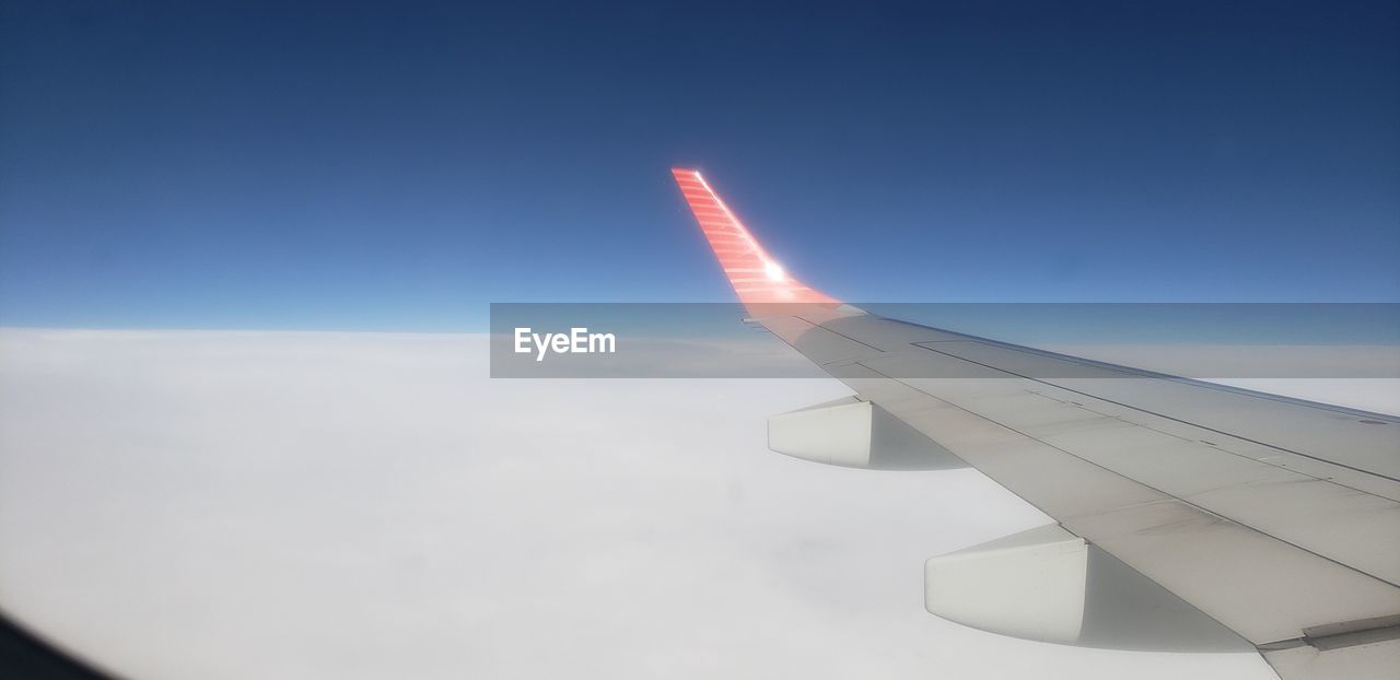 VIEW OF AIRPLANE WING AGAINST SKY