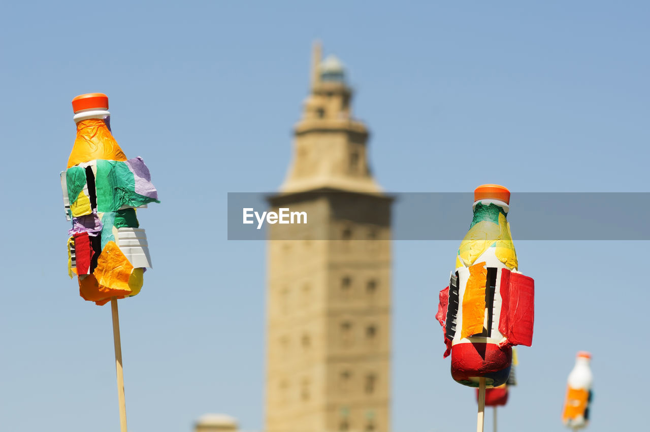 Tower of hercules and toys against sky