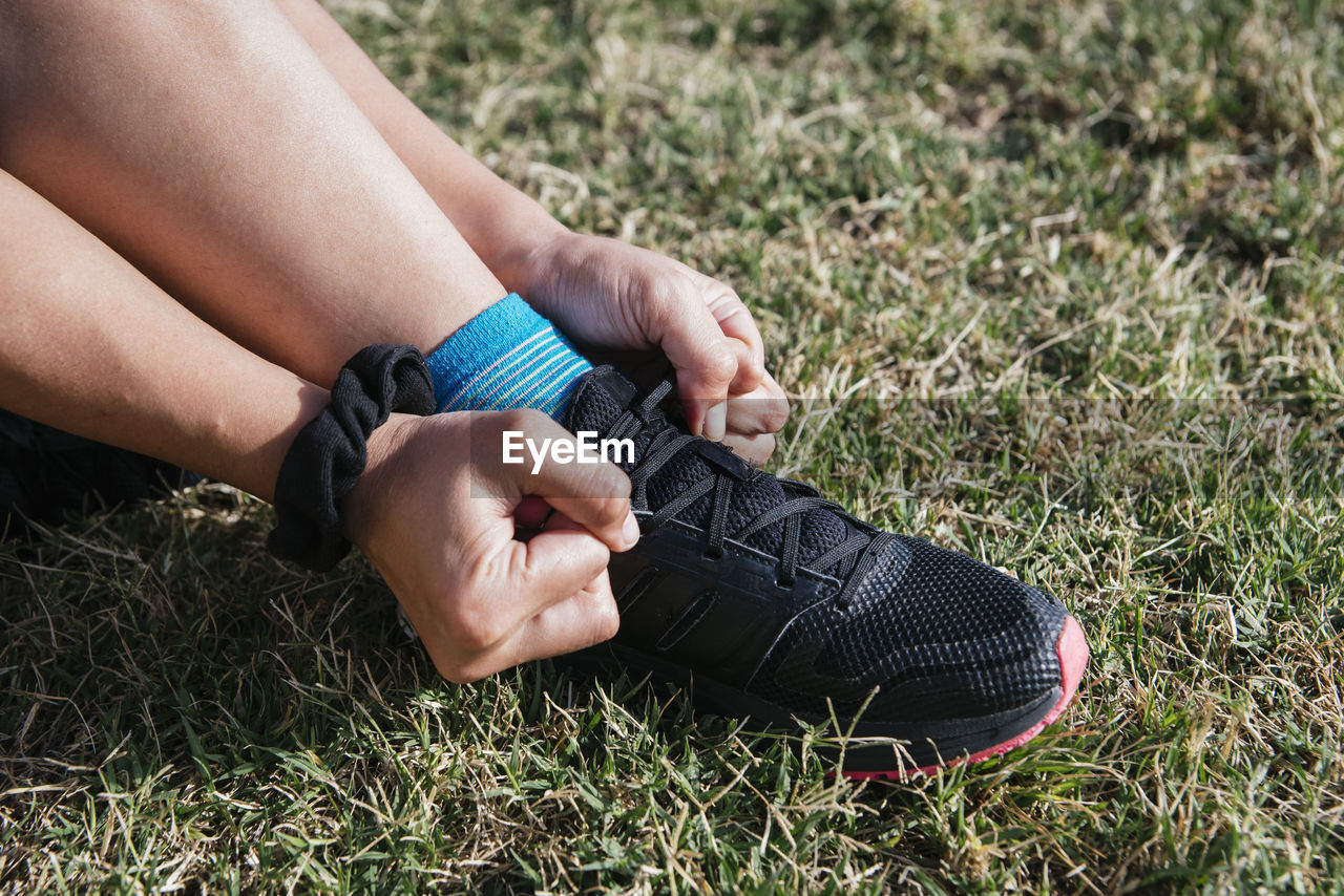 Girl tying shoelaces in the grass