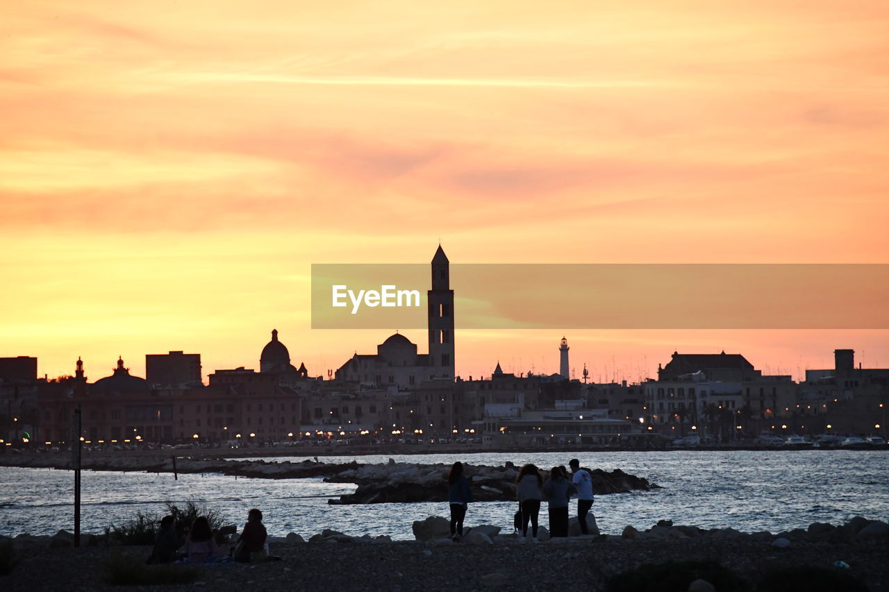 SILHOUETTE OF BUILDINGS AT WATERFRONT