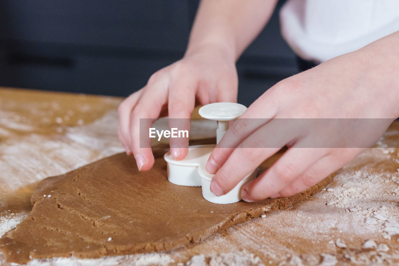 A little girl makes heart-shaped cookies from rye dough. the concept of valentine's day