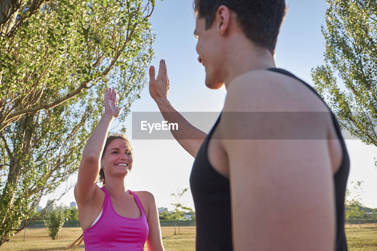 Athletes high fiving eachother during workout in public park