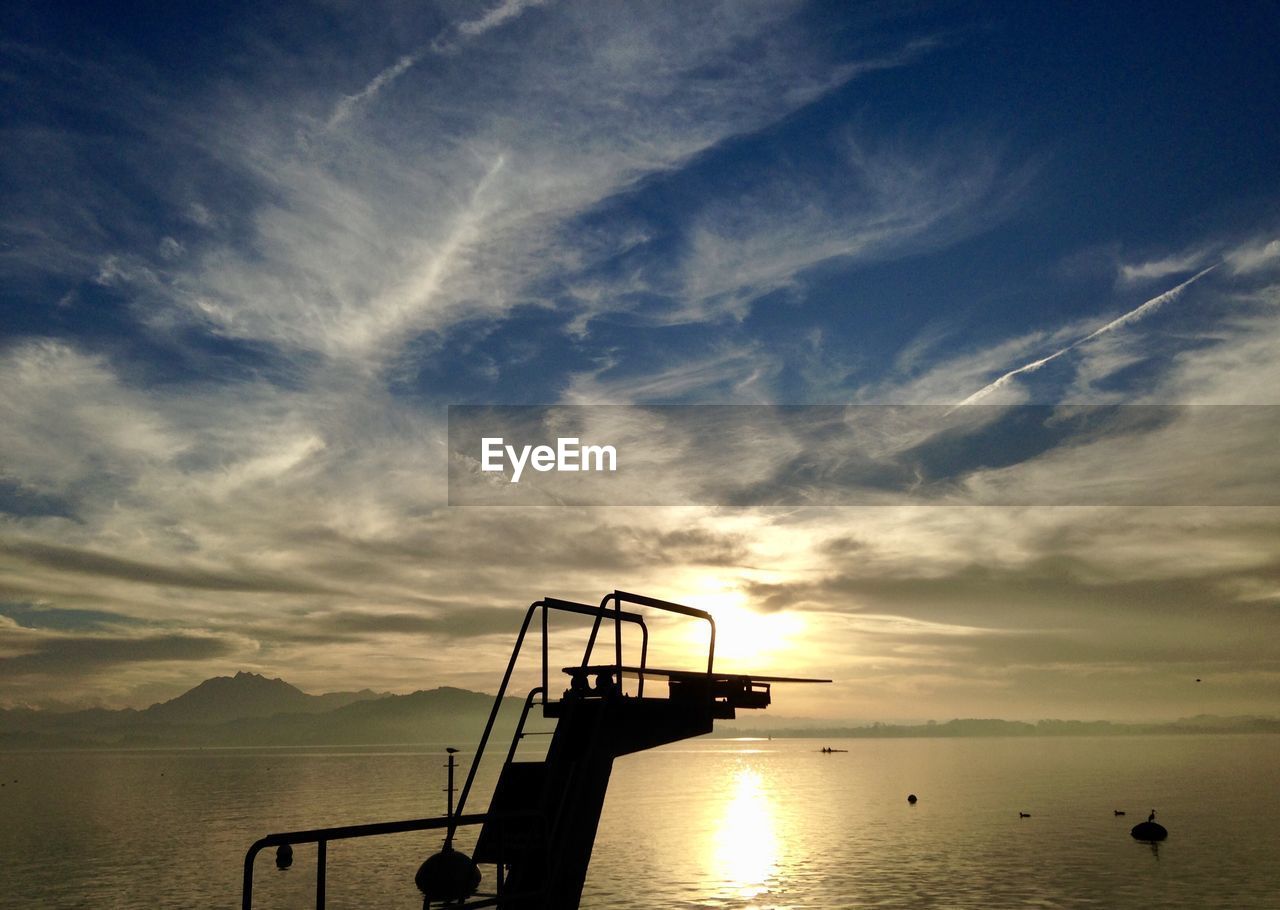 Silhouette boat in sea against sky during sunset