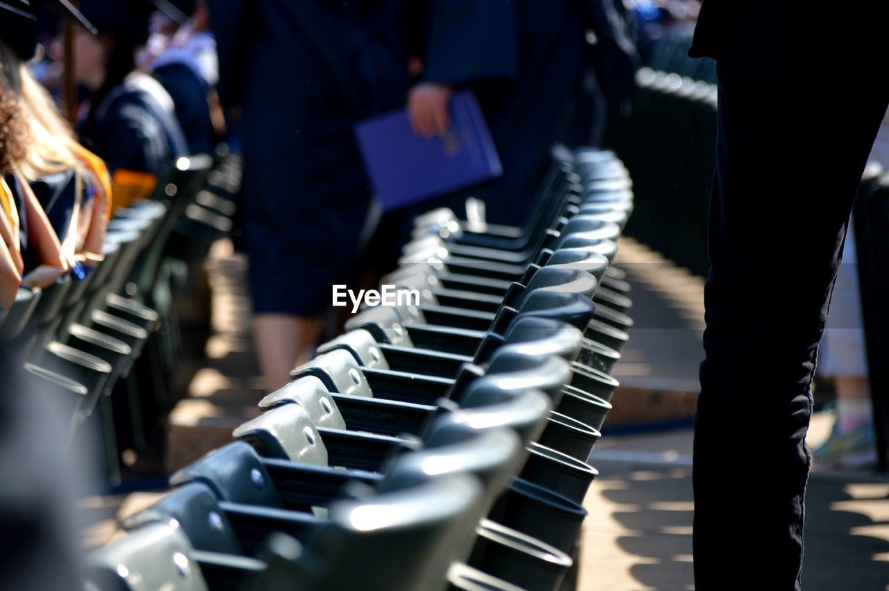 People by seats at webster university during graduation ceremony