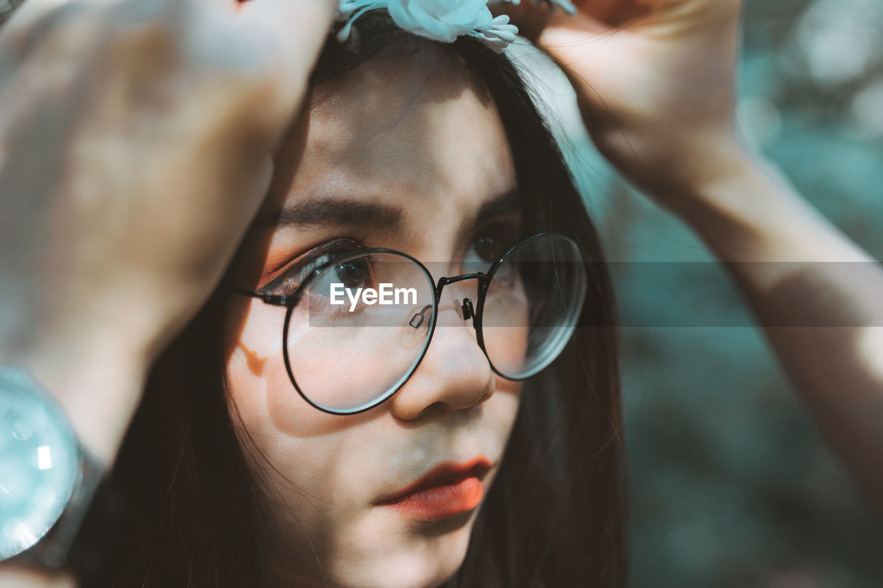 CLOSE-UP PORTRAIT OF YOUNG WOMAN WITH EYEGLASSES