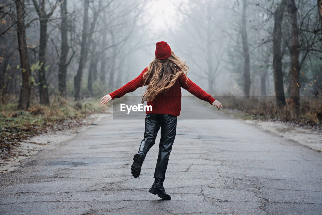 Weekend breaks and getaways in forests. stay close to nature. young woman in red hat and sweater