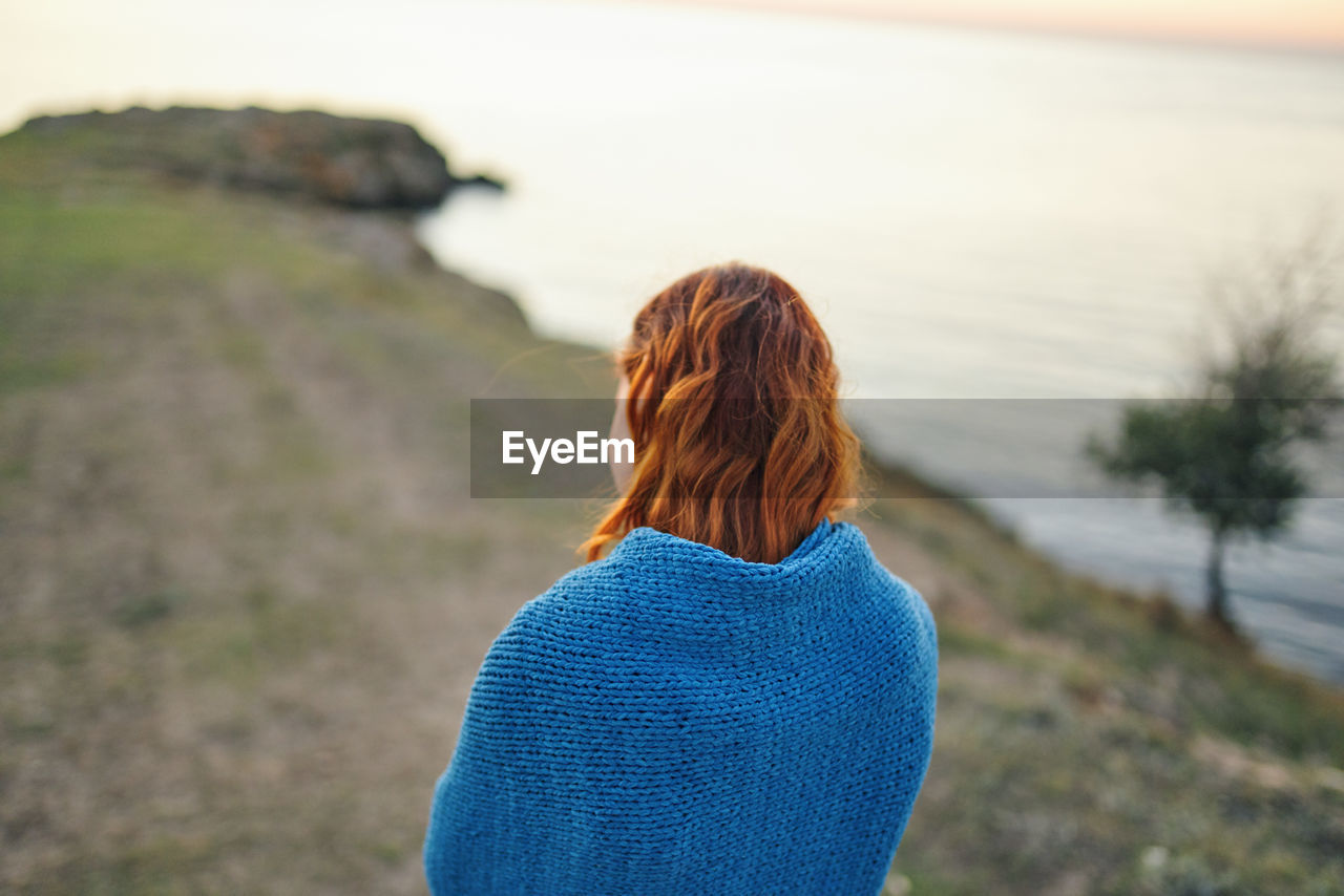 REAR VIEW OF WOMAN LOOKING AT VIEW