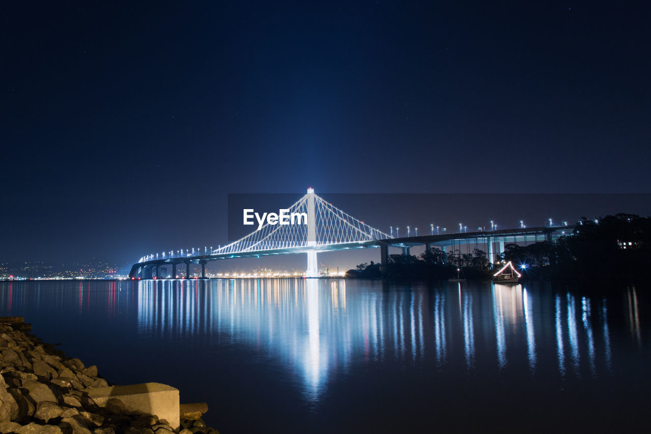 Suspension bridge over river at night