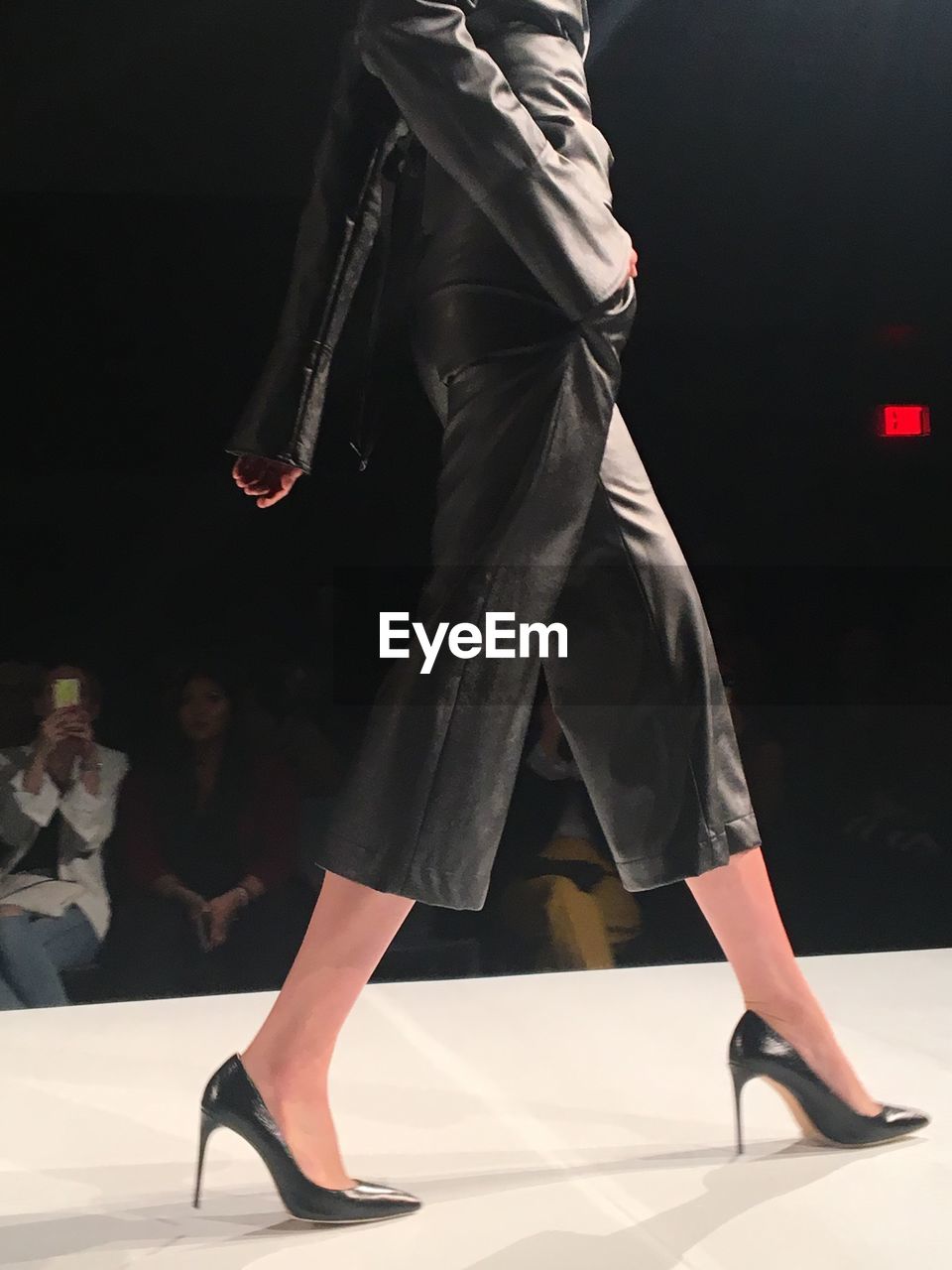 Low section of model doing catwalk at fashion show