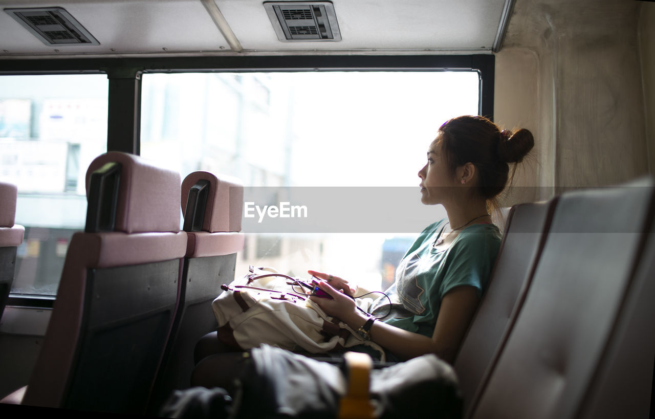 Side view of woman sitting in bus