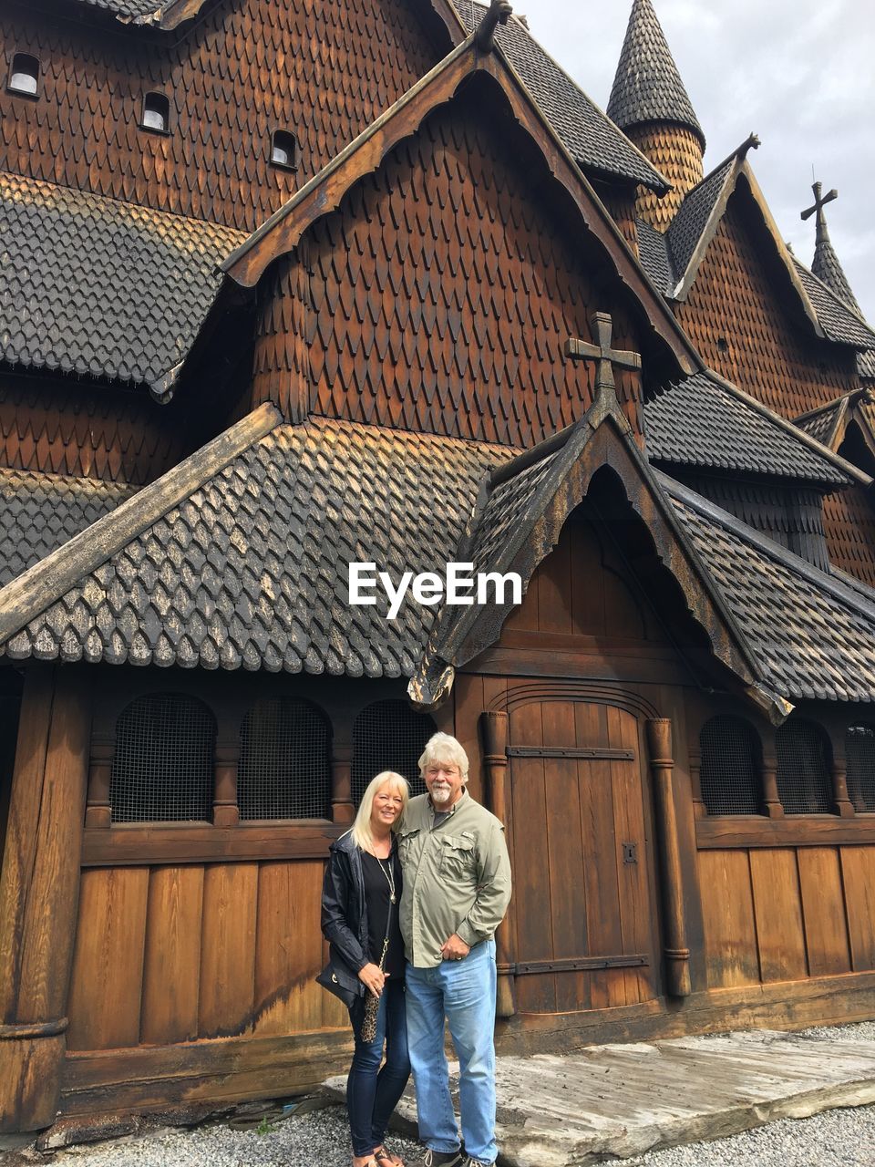 Full length of senior couple standing against church