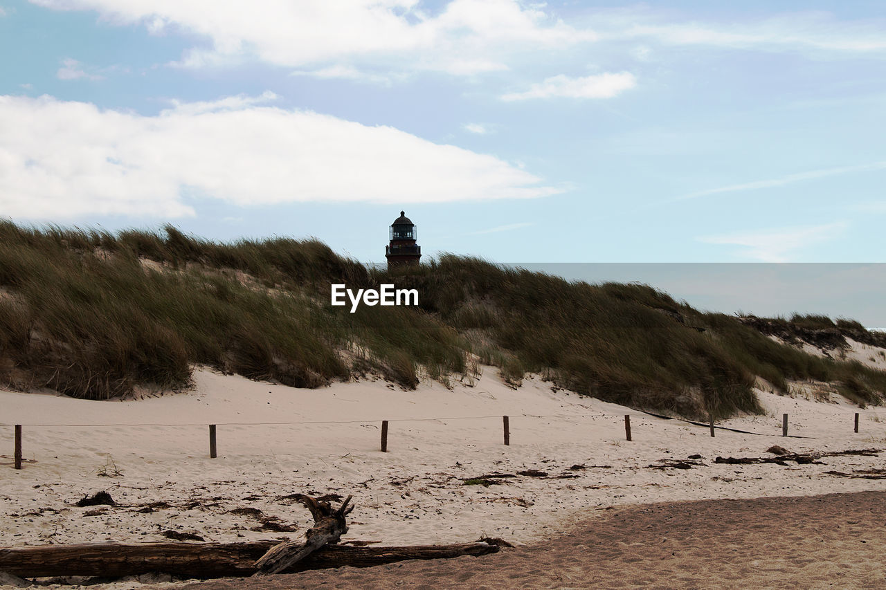 Scenic view of beach against cloudy sky