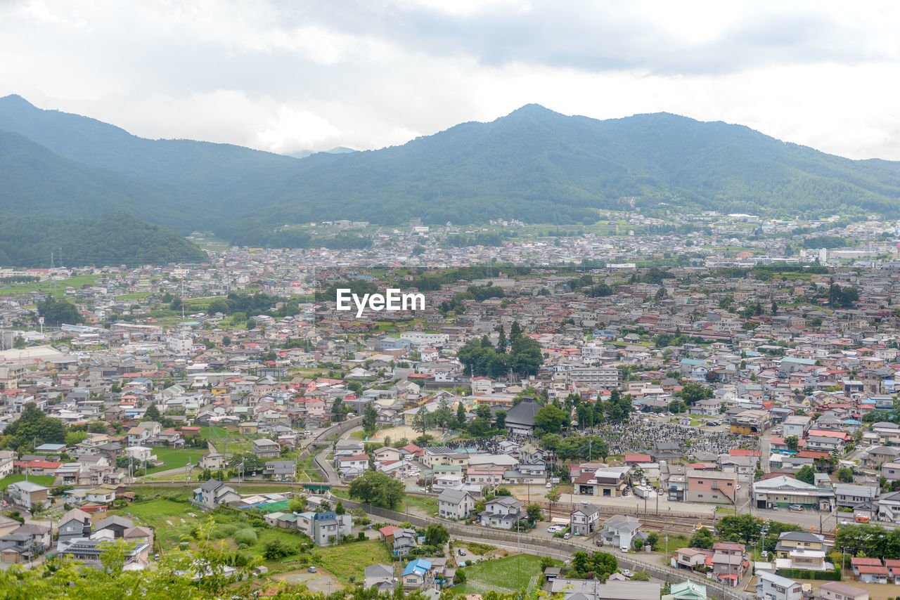 HIGH ANGLE VIEW OF TOWN AGAINST MOUNTAINS