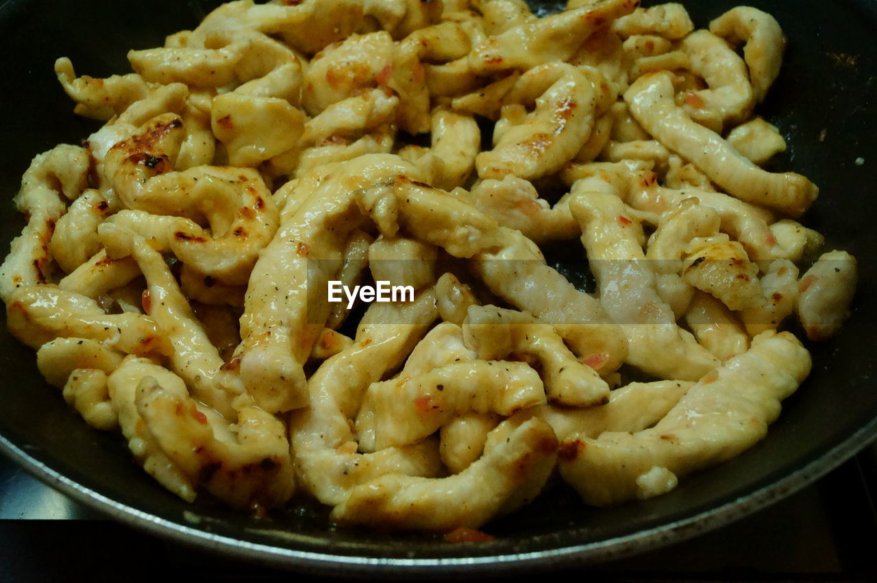 CLOSE-UP OF MEAT IN COOKING PAN