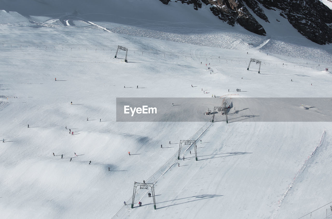 Skiing tracks and cable car road on snowed sunny slope of austria alps