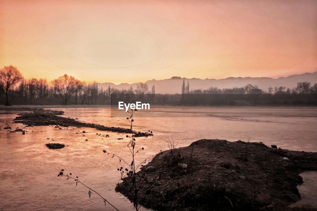 Scenic view of lake against sky during sunset