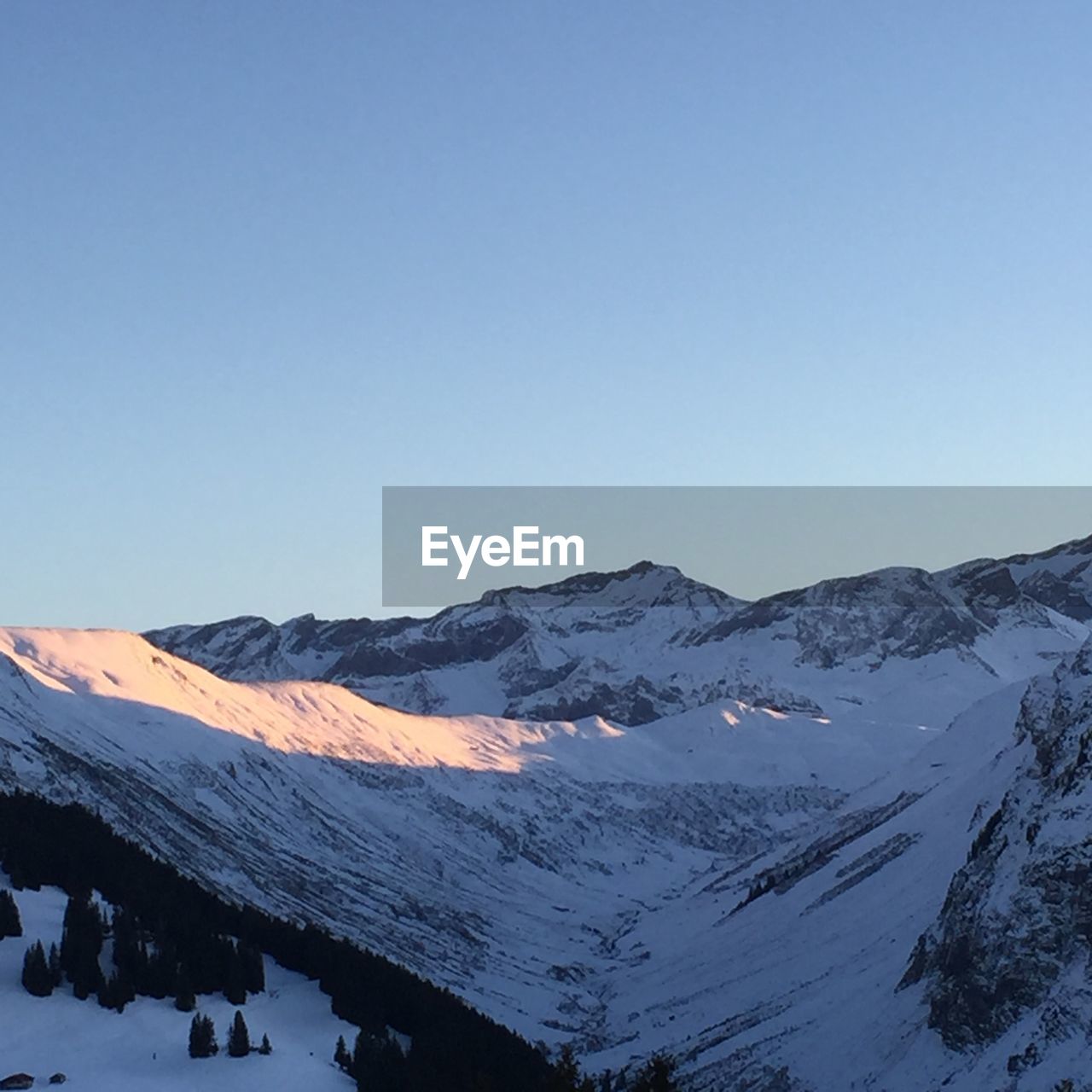 Scenic view of snow covered mountains against clear sky