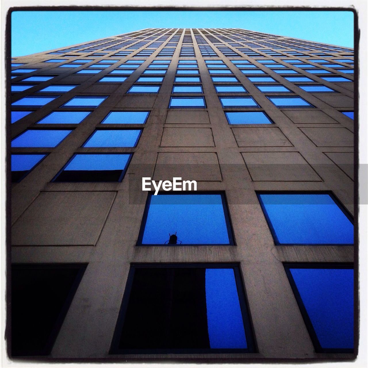 LOW ANGLE VIEW OF MODERN BUILDING AGAINST BLUE SKY