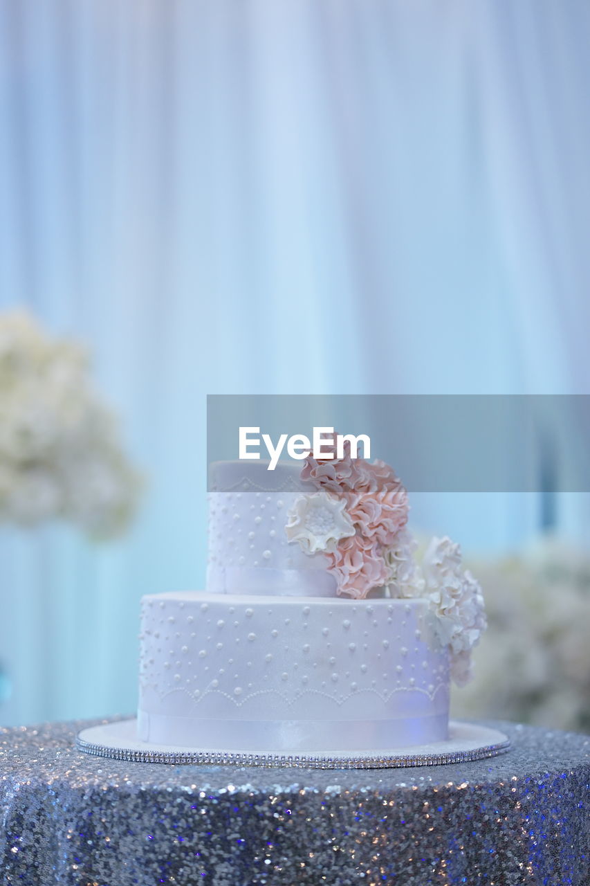 Close-up of white wedding cake against blurred background