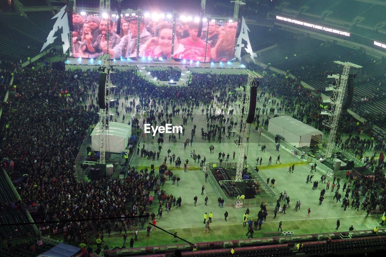 HIGH ANGLE VIEW OF CROWD AT ILLUMINATED CITY AT NIGHT