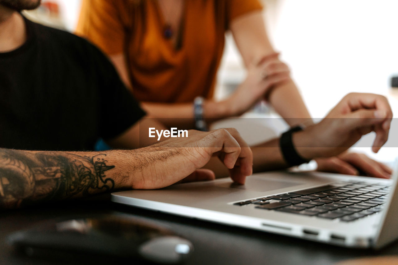 Detail of hand in laptop of couple having video conversation at home