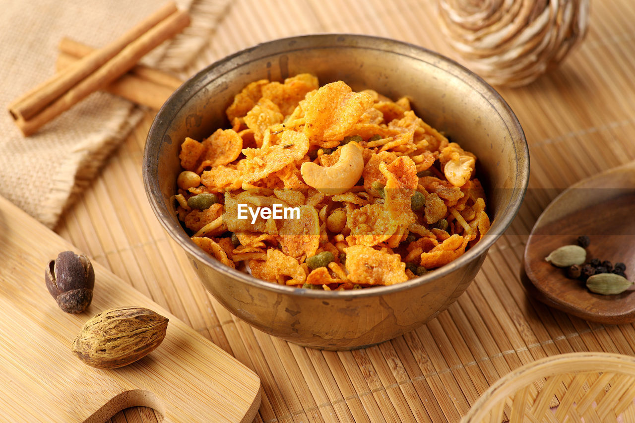 Indian snacks cornflakes namkeen food in an antique brass bowl