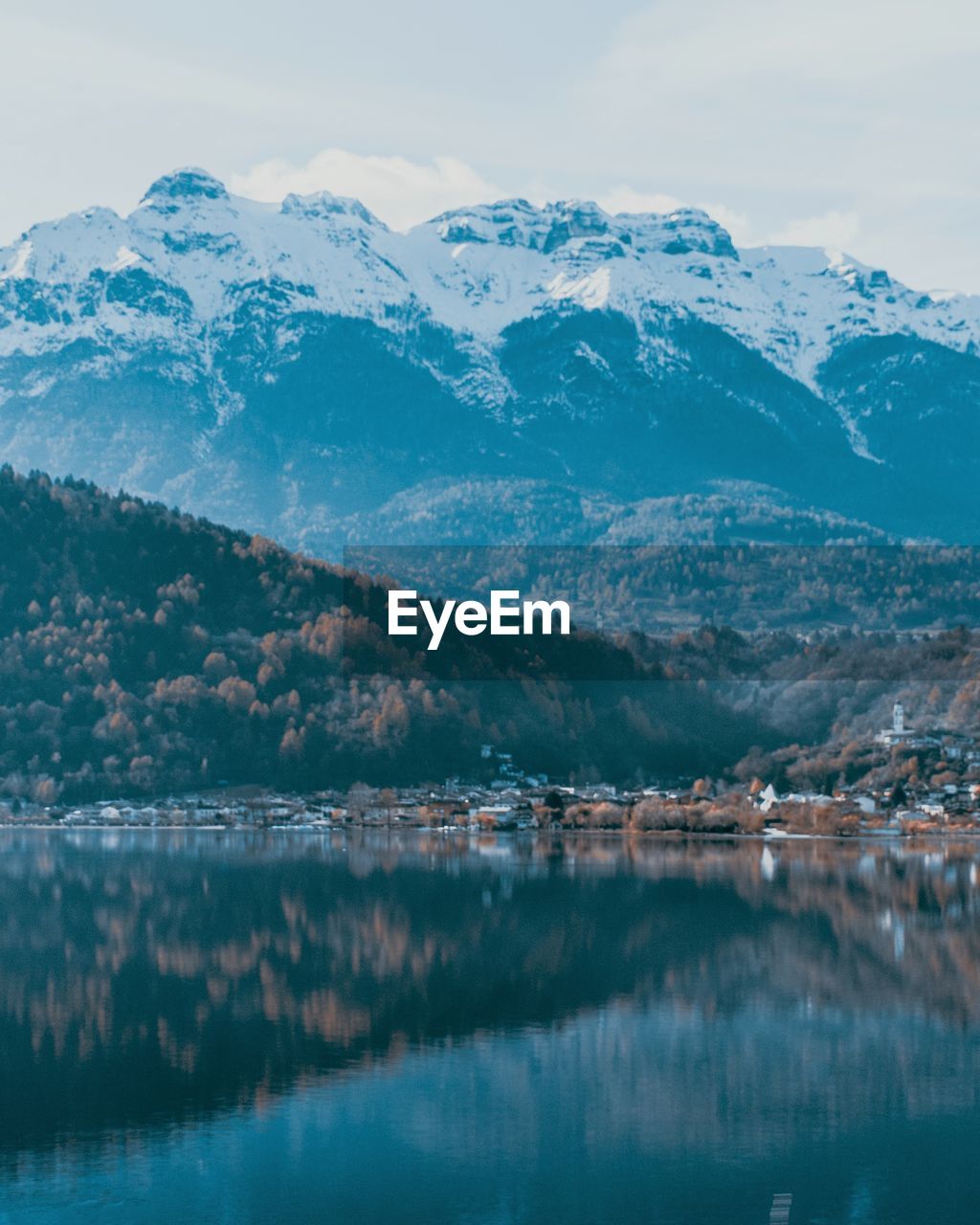 Scenic view of lake by snowcapped mountains against sky