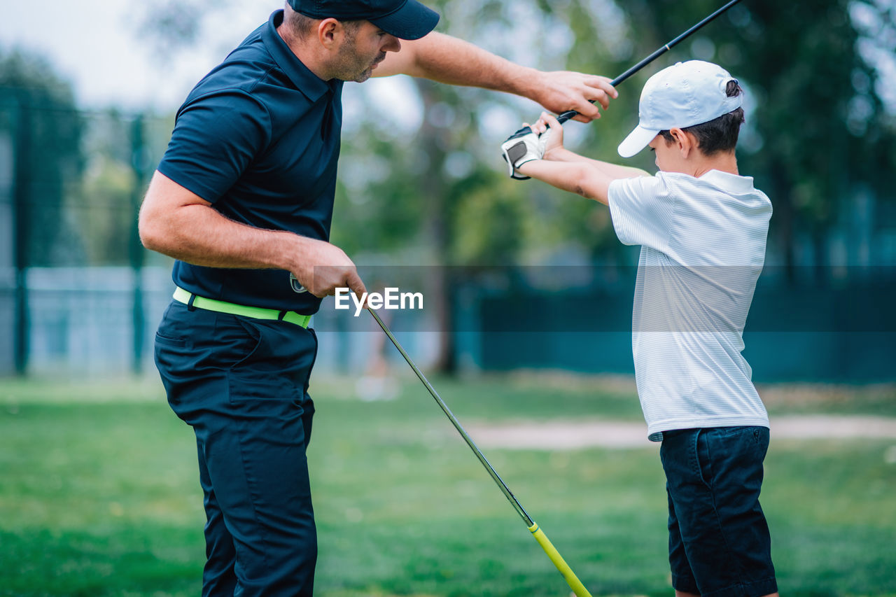 Rear view of man standing on golf course