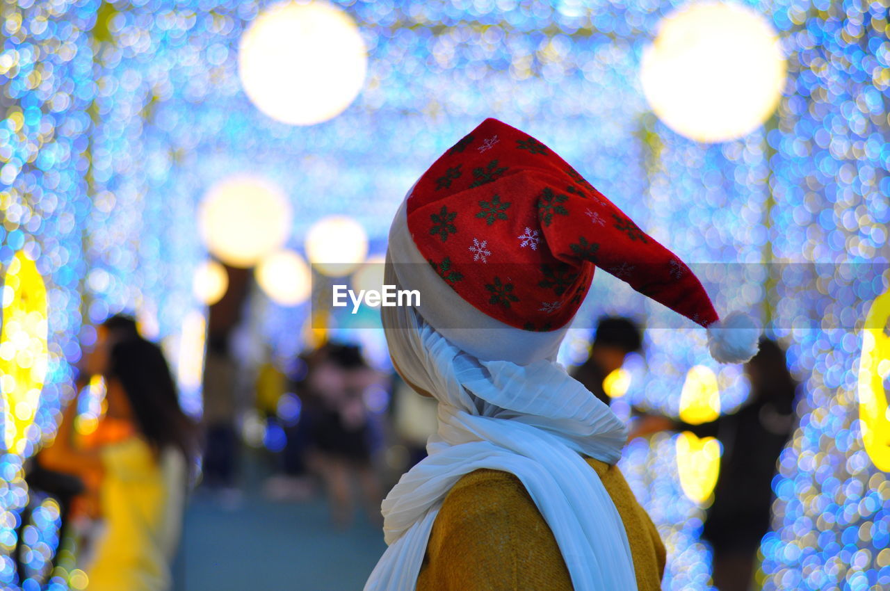 Side view of woman wearing santa hat at night
